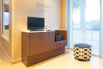 a room with a desk with a computer and a stool at Fairfield Inn & Suites by Marriott New York Queens/Fresh Meadows in Queens