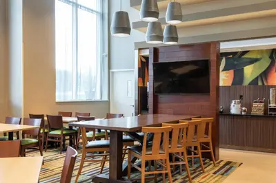 a dining room with a large table and chairs at Fairfield Inn & Suites by Marriott New York Queens/Fresh Meadows in Queens