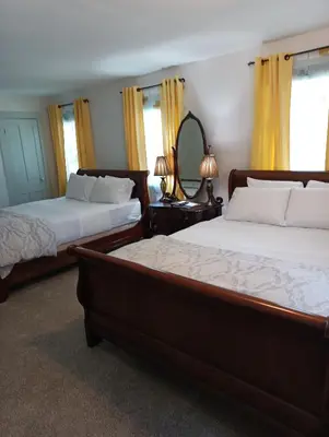 a bedroom with two beds and a mirror at Arlington Inn & Spa in Arlington