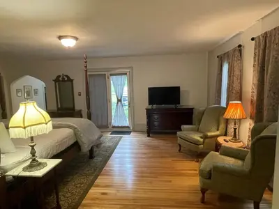 a bedroom with a bed and a chair and a television at Arlington Inn & Spa in Arlington