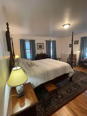 a bedroom with a bed and a table with a lamp at Arlington Inn & Spa in Arlington
