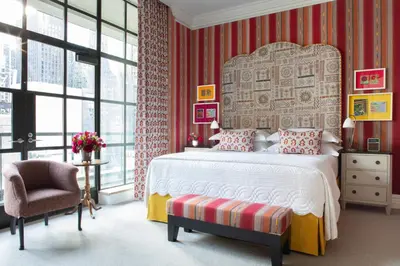 a bedroom with a bed and a chair and windows at The Whitby Hotel in New York