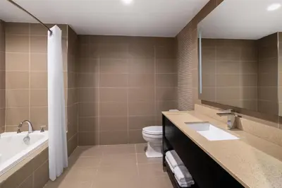 a bathroom with a tub and a toilet and a sink at Best Western Premier NYC Gateway Hotel in North Bergen