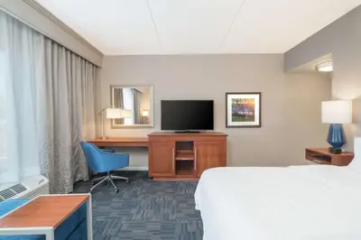 a hotel room with a bed and a desk and a television at Hampton Inn & Suites Newburgh Stewart Airport, NY in Newburgh