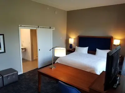 a bedroom with a bed and a desk with a television at Hampton Inn & Suites Newburgh Stewart Airport, NY in Newburgh