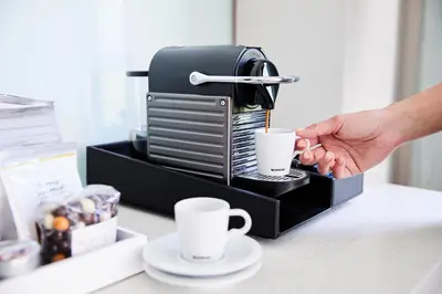 a person is making coffee in a coffee maker at Park Terrace Hotel in New York