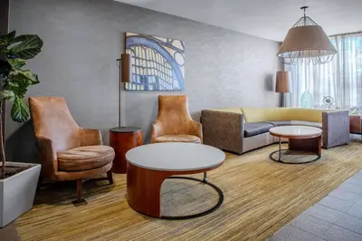 a living room with a couch and a table and chairs at Courtyard by Marriott Yonkers Westchester County in Yonkers