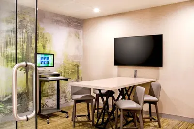 a conference room with a table and a tv on the wall at Courtyard by Marriott Yonkers Westchester County in Yonkers
