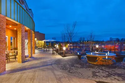 a patio with tables and chairs and a building at Courtyard by Marriott Yonkers Westchester County in Yonkers