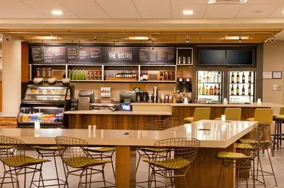 a restaurant with tables and chairs and a bar at Courtyard by Marriott Yonkers Westchester County in Yonkers