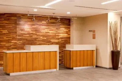 a lobby with two reception desks and a brick wall at Courtyard by Marriott Yonkers Westchester County in Yonkers
