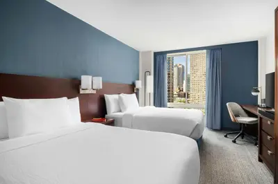 a hotel room with two beds and a window at Courtyard by Marriott New York Manhattan Upper East Side in New York