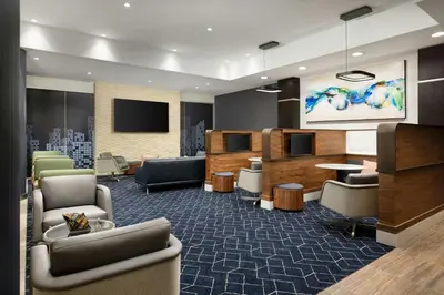 a lobby with a waiting room with chairs and a tv at Courtyard by Marriott New York Manhattan Upper East Side in New York