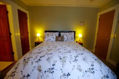 a large bed in a bedroom with two lamps at The Wilmington Inn in Wilmington