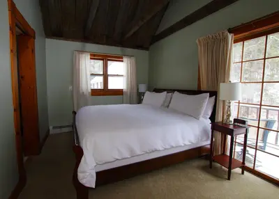 a bedroom with a white bed and two windows at The Wilmington Inn in Wilmington