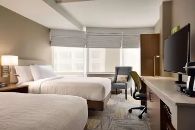 a hotel room with two beds and a flat screen tv at Hilton Garden Inn New York Times Square South in New York