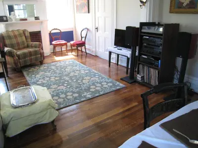 a living room with a hard wood floor and a television at Higganum House B&B in Higganum