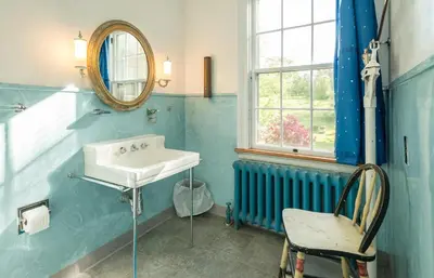 a blue bathroom with a sink and a chair at Higganum House B&B in Higganum