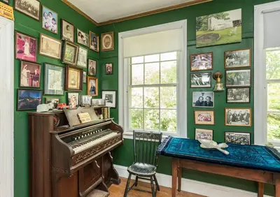 a room with a piano and pictures on the wall at Higganum House B&B in Higganum