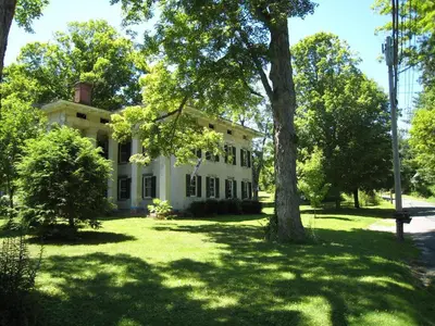 an old white house with a tree in the yard at Higganum House B&B in Higganum