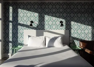 a bedroom with a white bed with a blue wall at Wythe Hotel in Brooklyn