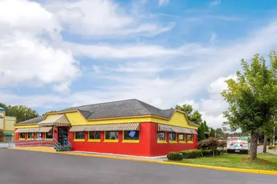 a red and yellow building on the side of a street at Days Inn & Suites by Wyndham Albany in Albany