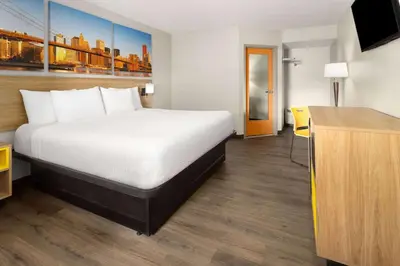 a hotel room with a bed and a desk at Days Inn & Suites by Wyndham Albany in Albany