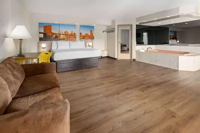 a large room with a bed and a couch at Days Inn & Suites by Wyndham Albany in Albany