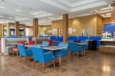 a restaurant with blue and red chairs and tables at Holiday Inn Express - Springfield Downtown by IHG in Springfield