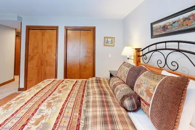 a bedroom with a large bed with a wooden headboard at The Seasons H23 in Dover