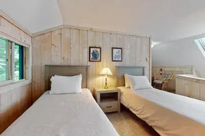 two beds in a room with wooden walls at Valley View: Forest Edge 189 in Dover