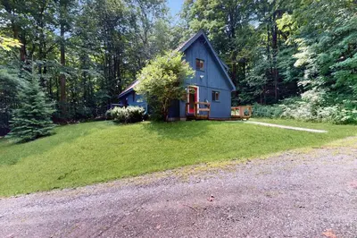 a blue house in the middle of a yard at Valley View: Forest Edge 189 in Dover