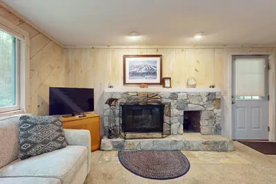 a living room with a stone fireplace and a couch at Valley View: Forest Edge 189 in Dover