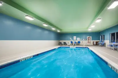 a swimming pool with blue water in a room at Holiday Inn Express Queensbury-Lake George Area by IHG in Queensbury