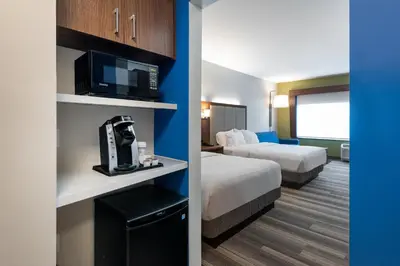 a hotel room with two beds and a tv and a room at Holiday Inn Express Queensbury-Lake George Area by IHG in Queensbury