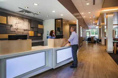 a man standing at a counter in a lobby at Holiday Inn Express Queensbury-Lake George Area by IHG in Queensbury