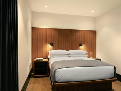 a bedroom with a large bed with a wooden headboard at The Moore, New York City, a Member of Design Hotels in New York
