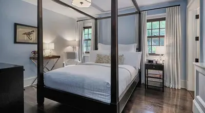 a bedroom with a four poster bed with white sheets at Bedford Post Inn in Bedford