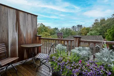 a balcony with a table and chairs and flowers at Bedford Post Inn in Bedford