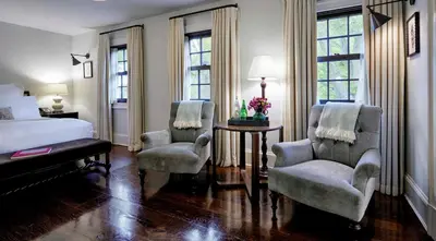 a bedroom with two chairs and a bed and a table at Bedford Post Inn in Bedford