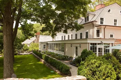 a large white house with a tree in the yard at Bedford Post Inn in Bedford