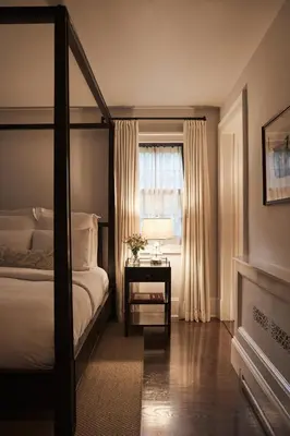 a bedroom with a canopy bed and a table with a window at Bedford Post Inn in Bedford