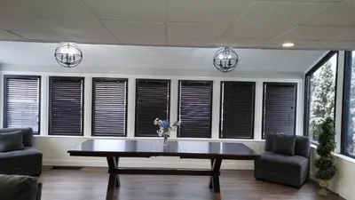 a dining room with a table and chairs and windows at Lily's Lodge in West Springfield