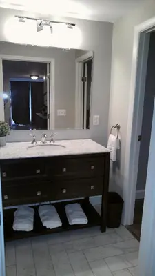 a bathroom with a sink and a large mirror at Lily's Lodge in West Springfield