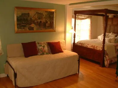 a living room with a couch and a bed at Truman Gillet House B & B in Granby