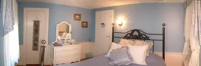 a bedroom with a bed and a dresser and a mirror at Truman Gillet House B & B in Granby