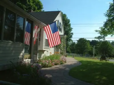 two american flags on the side of a house at Truman Gillet House B & B in Granby
