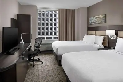 a hotel room with two beds and a desk and a television at Hilton Garden Inn NYC Financial Center/Manhattan Downtown in New York