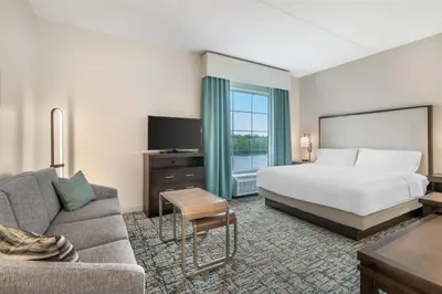 a hotel room with a bed and a couch at Homewood Suites By Hilton Schenectady in Schenectady