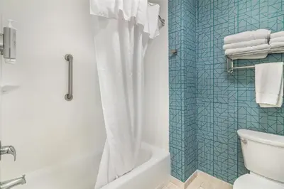a bathroom with a tub and a shower with a toilet at Homewood Suites By Hilton Schenectady in Schenectady